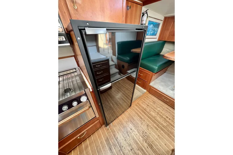 Slide: The Image of 1985 Tollycraft 48 Cockpit Motor Yacht interior with kitchen and dining area. - 68
