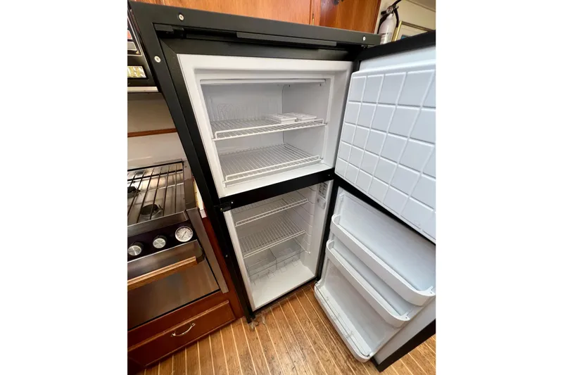 Slide: The Image of Open refrigerator in 1985 Tollycraft 48 Cockpit Motor Yacht kitchen, showing shelves and storage. - 69