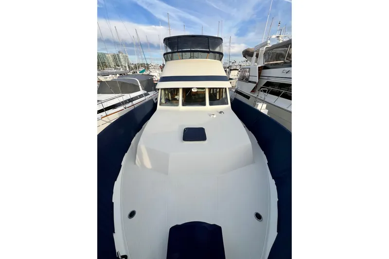 Slide: The Image of 1985 Tollycraft 48 Cockpit Motor Yacht docked at marina, showcasing spacious deck. - 7