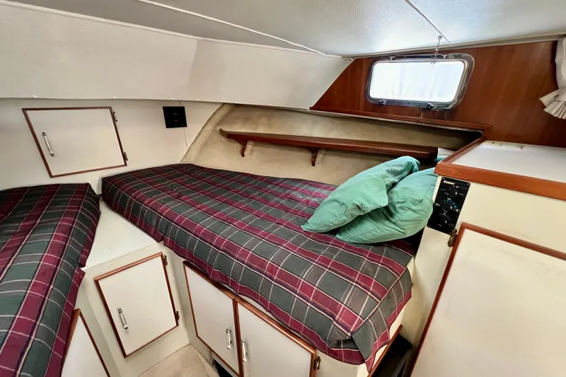 Slide: The Image of 1985 Tollycraft 48 Cockpit Motor Yacht cabin with twin beds and storage cabinets. - 73