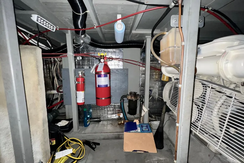 Slide: The Image of Engine room of 1985 Tollycraft 48 Cockpit Motor Yacht with fire extinguishers and wiring. - 82