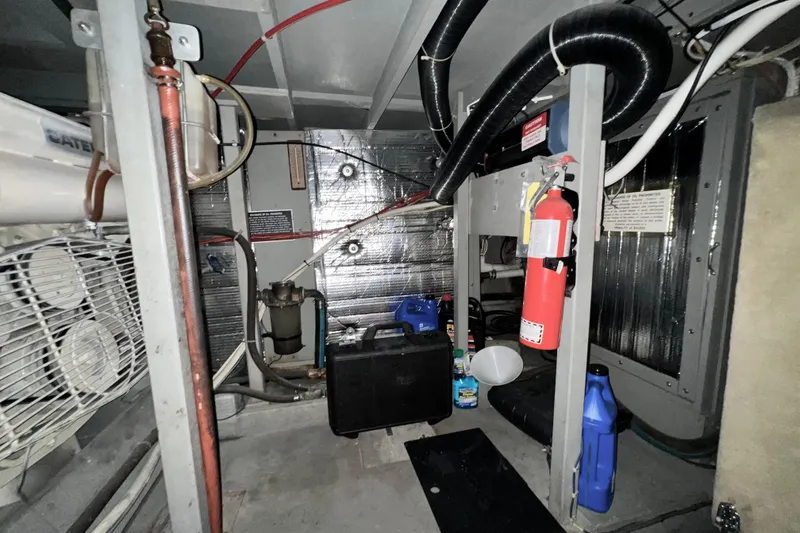 Slide: The Image of Engine room of 1985 Tollycraft 48 Cockpit Motor Yacht with equipment and fire extinguisher. - 90