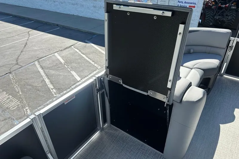 Slide: The Image of 2026 Tahoe Pontoon LTZ Quad Lounger Shift 23 interior with seating and storage compartment. - 21