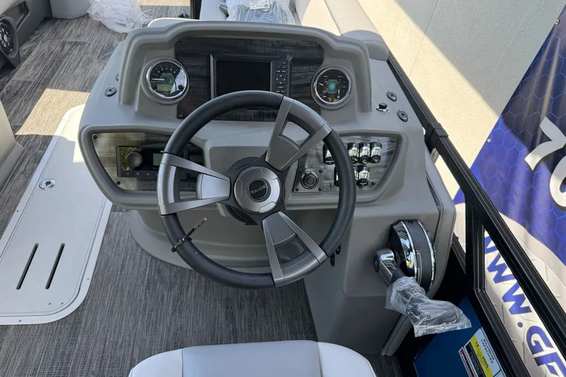Slide: The Image of 2026 Tahoe Pontoon Sport 85 Elite Windshield 25 dashboard with steering wheel and controls. - 12