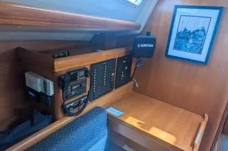 Slide: The Image of 2004 Hunter 33 yacht interior with navigation equipment and framed artwork. - 22
