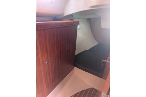 Slide: The Image of 2004 Hunter 33 sailboat interior with wood storage cabinet and double berth. - 28