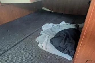 Slide: The Image of Interior cabin of 2004 Hunter 33 sailboat with folded fabric on the double berth. - 30