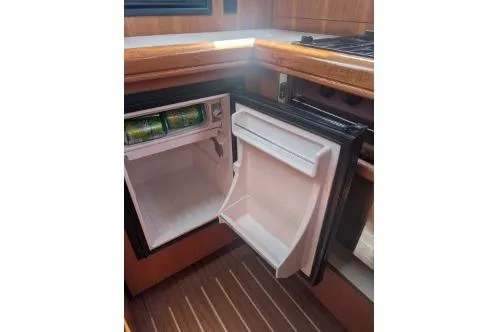 Slide: The Image of Open mini fridge in 2004 Hunter 33 yacht kitchen, showing interior shelves. - 35