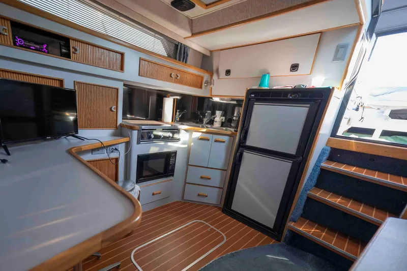 Slide: The Image of Interior of 1991 Sea Ray 390 Express Cruiser with kitchen and appliances. - 15