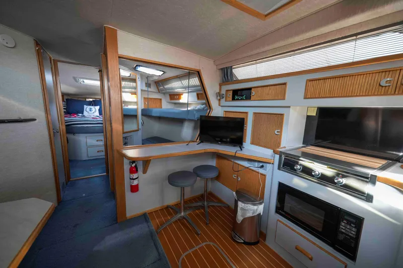 Slide: The Image of Interior of a 1991 Sea Ray 390 Express Cruiser with modern kitchen and cozy seating. - 17