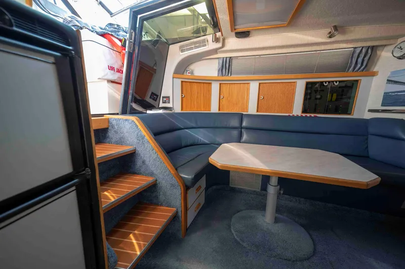 Slide: The Image of Interior of 1991 Sea Ray 390 Express Cruiser with blue seating and wooden accents. - 21