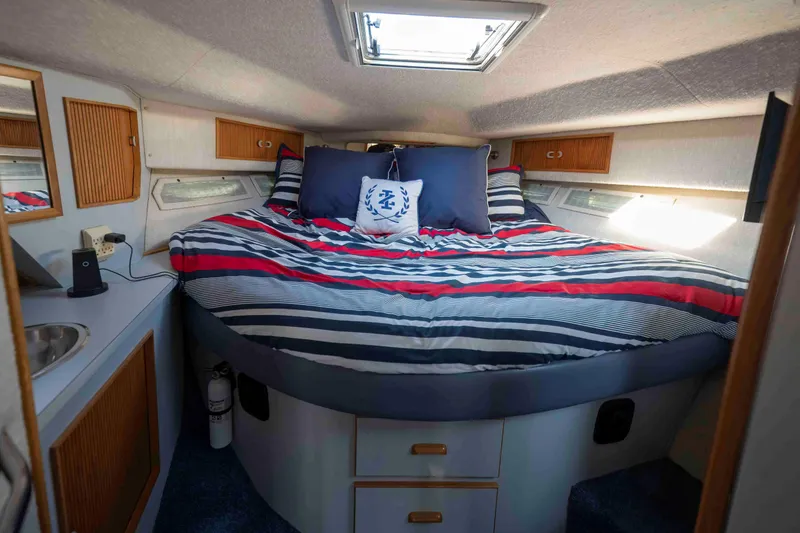 Slide: The Image of Interior cabin of 1991 Sea Ray 390 Express Cruiser with striped bedding and nautical decor. - 23