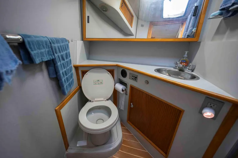 Slide: The Image of Bathroom interior of 1991 Sea Ray 390 Express Cruiser with toilet, sink, and mirror. - 26