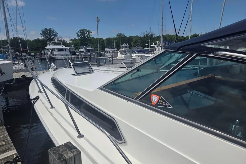Slide: The Image of 1991 Sea Ray 390 Express Cruiser docked at a marina under a clear blue sky. - 45