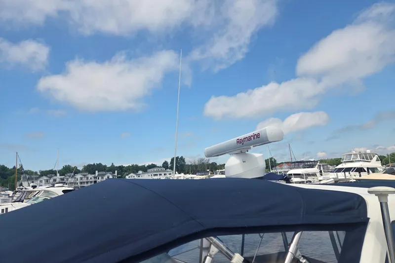 Slide: The Image of 1991 Sea Ray 390 Express Cruiser with Raymarine radar in a marina under blue skies. - 46