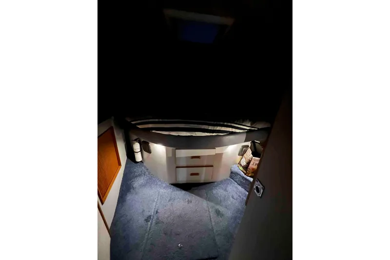 Slide: The Image of 1991 Sea Ray 390 Express Cruiser cabin interior with bed and blue carpet. - 48
