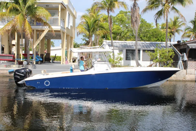 The Image of 2007 Fountain 34 Center Console boat on water, surrounded by palm trees and waterfront homes. - 0