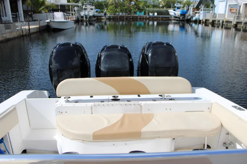 Slide: The Image of 2007 Fountain 34 Center Console boat with triple outboard engines docked in a serene marina. - 10
