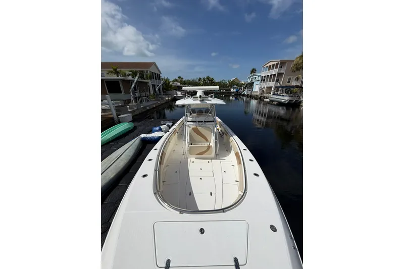 Slide: The Image of 2007 Fountain 34 Center Console boat docked in a serene canal setting. - 20