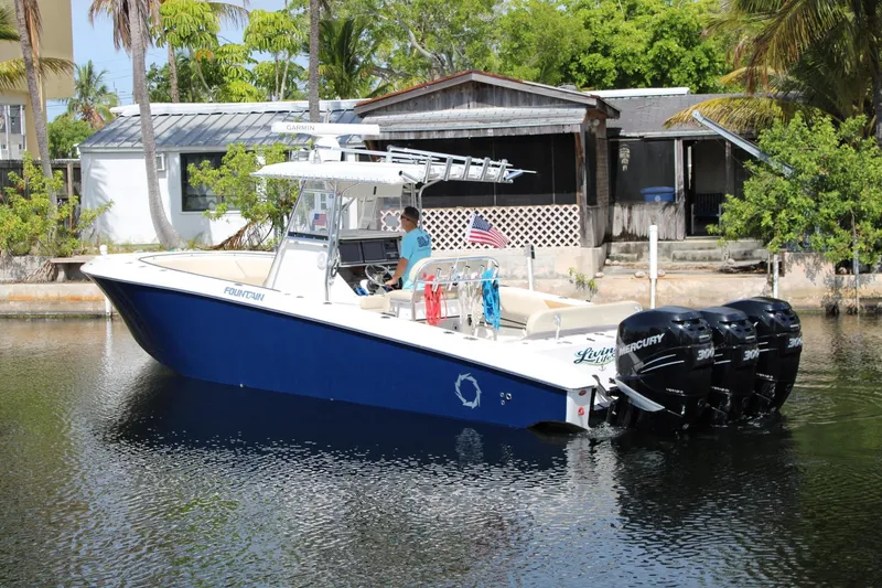 Slide: The Image of 2007 Fountain 34 Center Console boat with triple Mercury engines on a calm waterway. - 3
