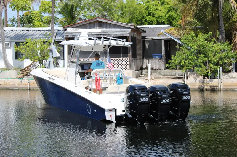 Slide: The Image of 2007 Fountain 34 Center Console boat with four Mercury 300 engines on a calm waterway. - 4