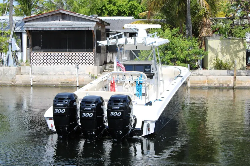 Slide: The Image of 2007 Fountain 34 Center Console boat with triple 300 horsepower engines docked by a waterfront. - 5