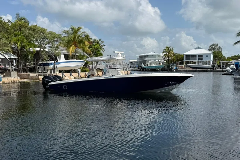 Slide: The Image of 2007 Fountain 34 Center Console boat docked in a scenic marina with palm trees. - 6