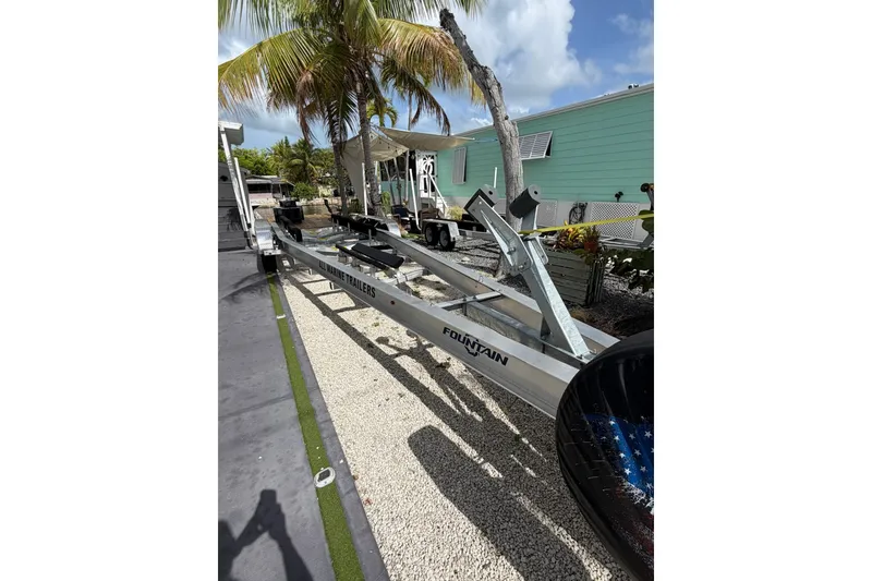 Slide: The Image of Trailer for 2007 Fountain 34 Center Console boat, parked outdoors near palm trees. - 7