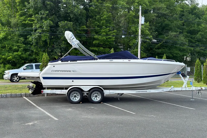 The Image of 2026 Chaparral SSX 4 boat on trailer in parking lot, surrounded by greenery. - 0