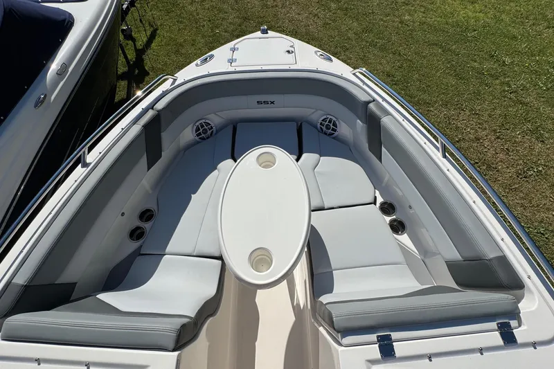 Slide: The Image of 2026 Chaparral SSX 4 boat interior with cushioned seating and oval table on grass. - 29