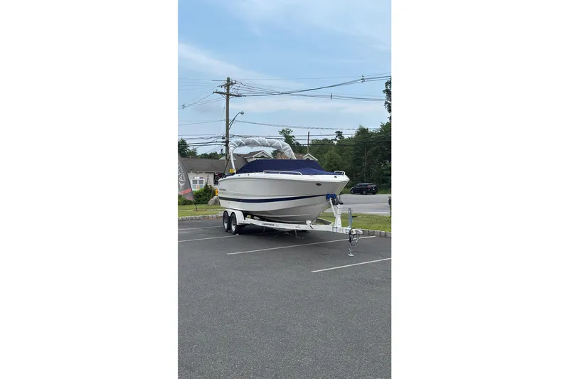 Slide: The Image of 2026 Chaparral SSX 4 boat on trailer in parking lot, clear sky background. - 4