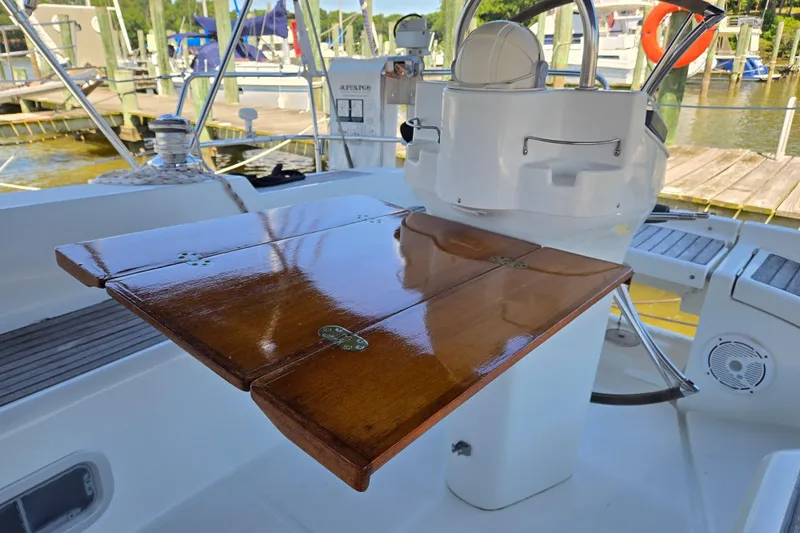 Slide: The Image of Cockpit of 2003 Beneteau 393 sailboat with polished wooden table and steering wheel. - 12