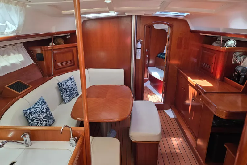 Slide: The Image of Interior of 2003 Beneteau 393 yacht with wooden furnishings and cozy seating area. - 17