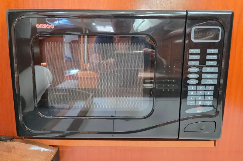 Slide: The Image of Built-in microwave on a 2003 Beneteau 393 yacht, featuring digital controls and wood paneling. - 20