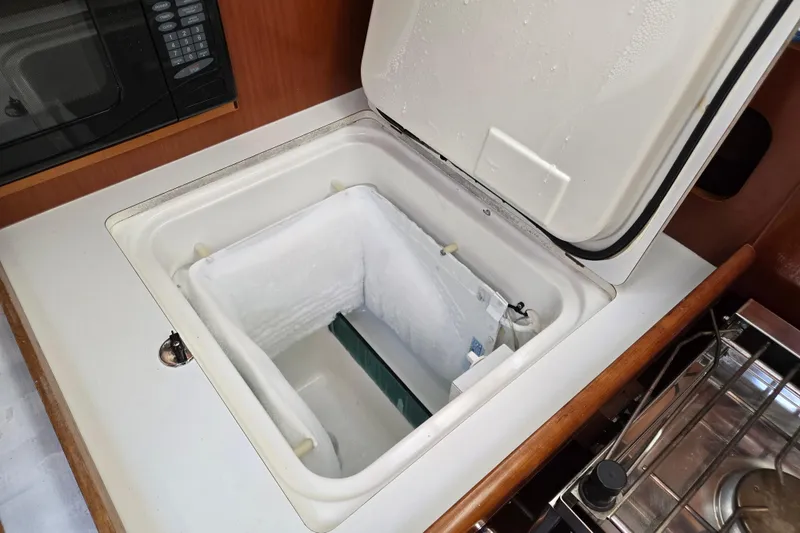 Slide: The Image of Open freezer compartment in 2003 Beneteau 393 yacht kitchen, showcasing interior storage space. - 21