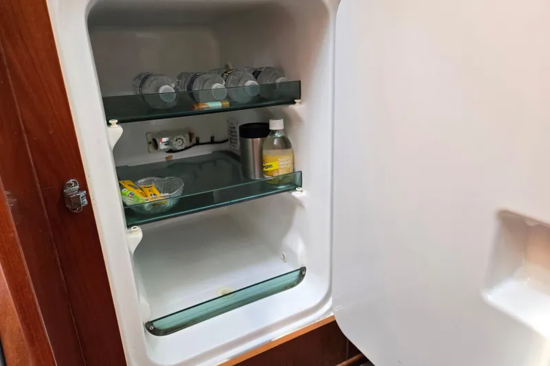 Slide: The Image of Open fridge inside 2003 Beneteau 393 yacht, containing drinks and small items. - 22