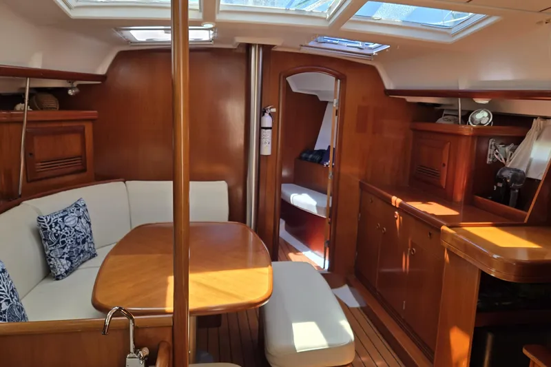 Slide: The Image of Interior of 2003 Beneteau 393 yacht with wooden furnishings and cozy seating area. - 28
