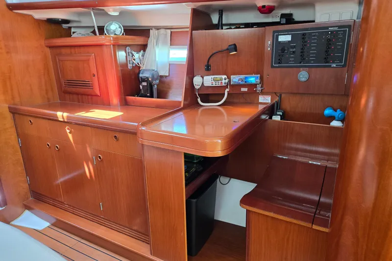 Slide: The Image of Interior of a 2003 Beneteau 393 sailboat with wooden cabinetry and navigation station. - 29