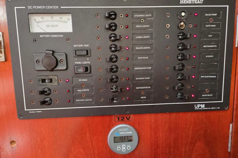 Slide: The Image of Control panel of a 2003 Beneteau 393 yacht, featuring various switches and a voltage meter. - 31