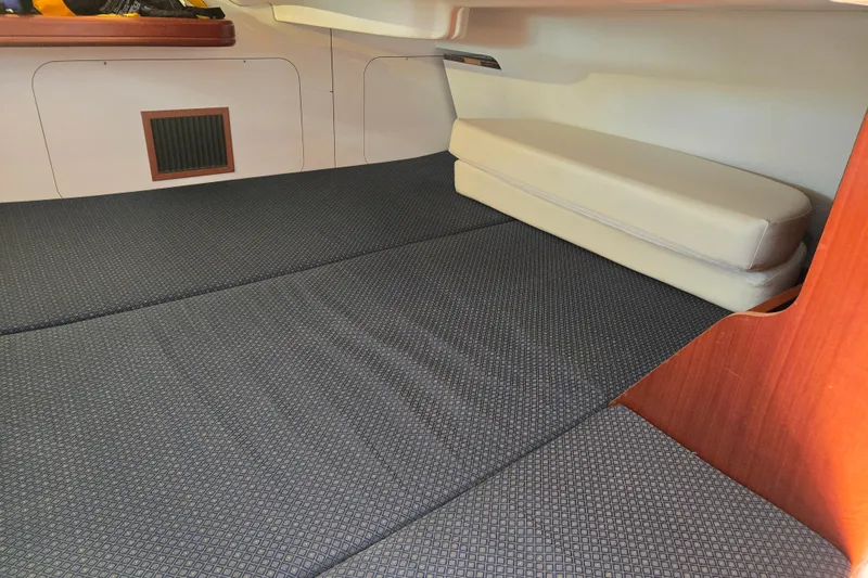 Slide: The Image of Interior cabin of a 2003 Beneteau 393 yacht, featuring cushioned seating and wooden accents. - 33
