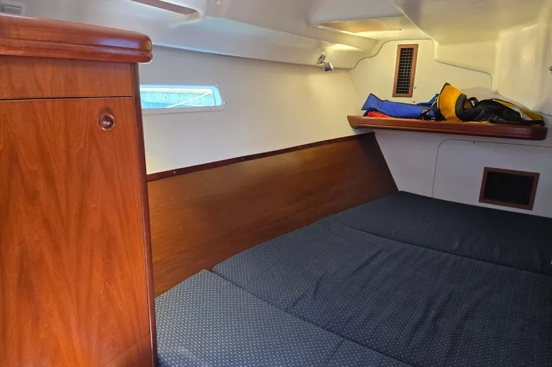 Slide: The Image of Cozy cabin interior of 2003 Beneteau 393 sailboat with wooden finish and storage space. - 35