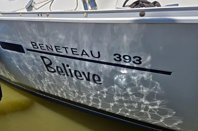 Slide: The Image of Side view of a 2003 Beneteau 393 sailboat named "Believe" with water reflections. - 4