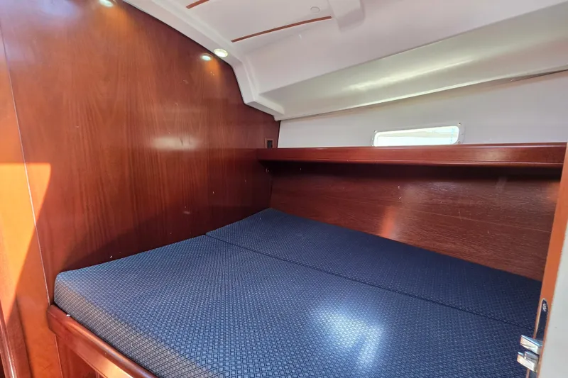 Slide: The Image of Interior cabin of 2003 Beneteau 393 sailboat with wooden finish and blue mattress. - 42