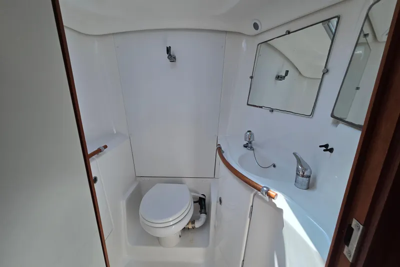 Slide: The Image of Bathroom interior of 2003 Beneteau 393 yacht, featuring toilet, sink, and mirror. - 43