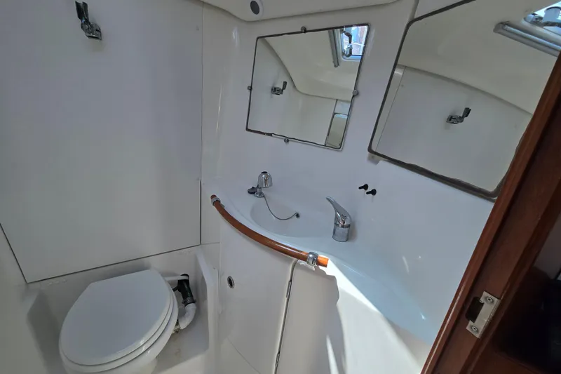 Slide: The Image of Bathroom interior of a 2003 Beneteau 393 yacht, featuring a toilet and sink. - 44