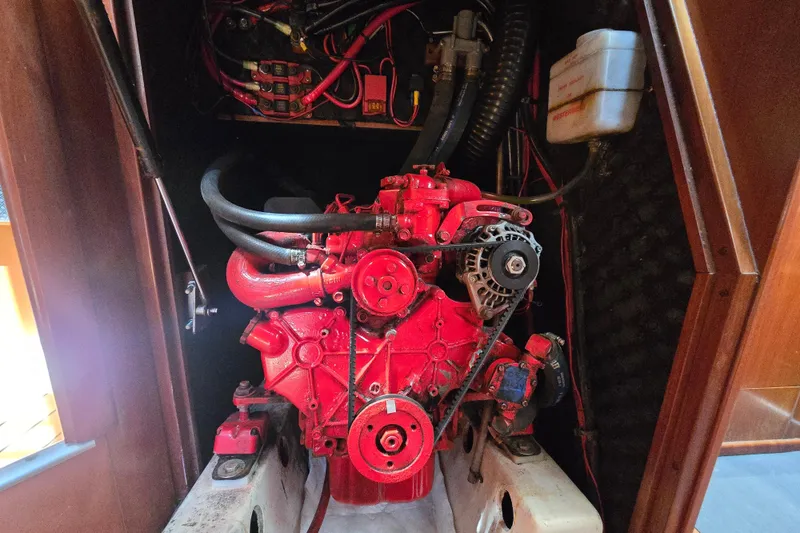 Slide: The Image of Engine compartment of a 2003 Beneteau 393 sailboat, featuring a red marine engine. - 48
