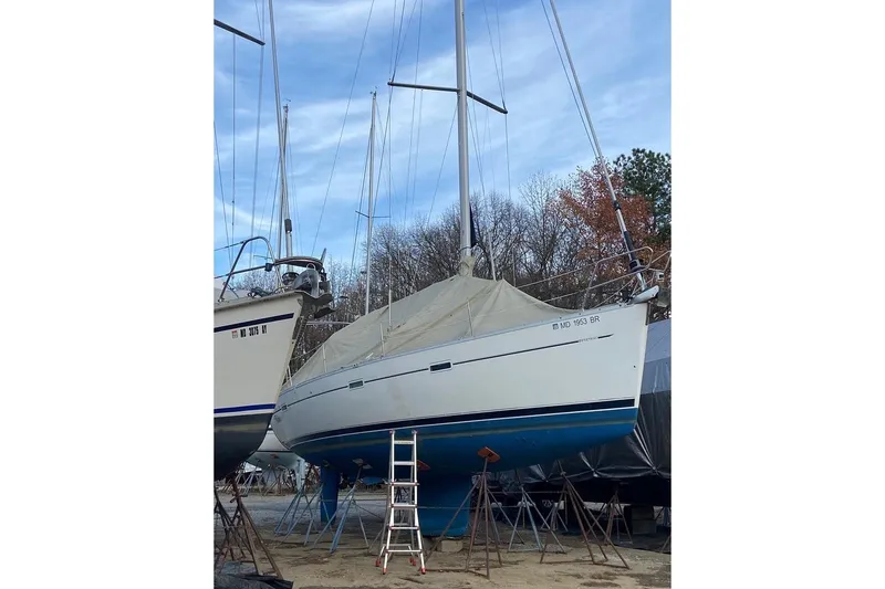 Slide: The Image of 2003 Beneteau 393 sailboat on dry dock, covered and supported by stands. - 49