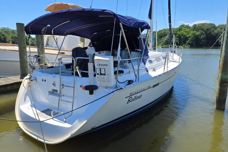 Slide: The Image of 2003 Beneteau 393 sailboat docked on calm water, featuring a blue canopy and sleek design. - 5