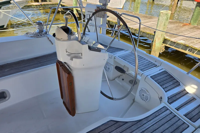 Slide: The Image of Cockpit of a 2003 Beneteau 393 sailboat with steering wheel and wooden accents. - 51