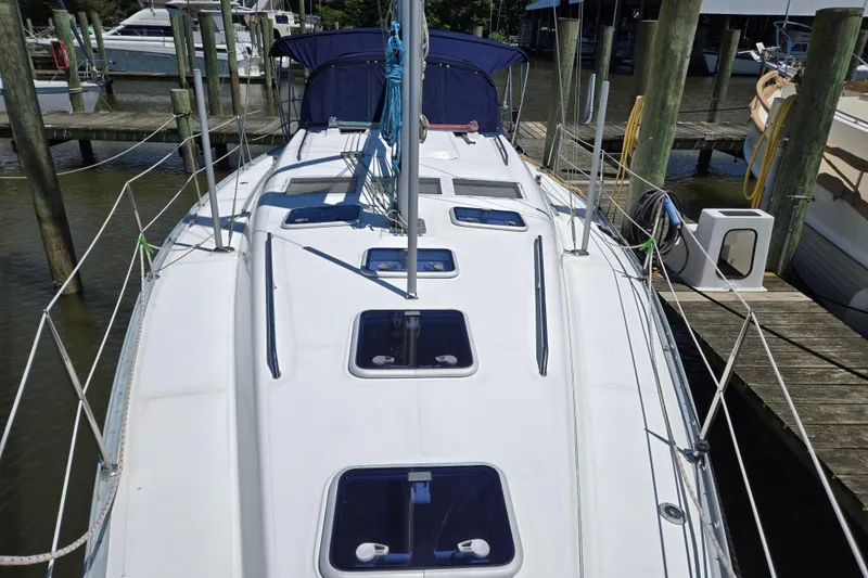 Slide: The Image of 2003 Beneteau 393 sailboat docked, showcasing deck and hatches. - 8